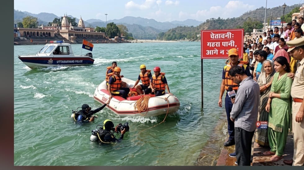 ऋषिकेश के त्रिवेणी घाट पर गंगा नदी के तेज बहाव के बीच नाव और लाइफ जैकेट के साथ लापता किशोर की तलाश करते हुए एसडीआरएफ और जल पुलिस के जवान, किनारे पर मौजूद श्रद्धालु। |