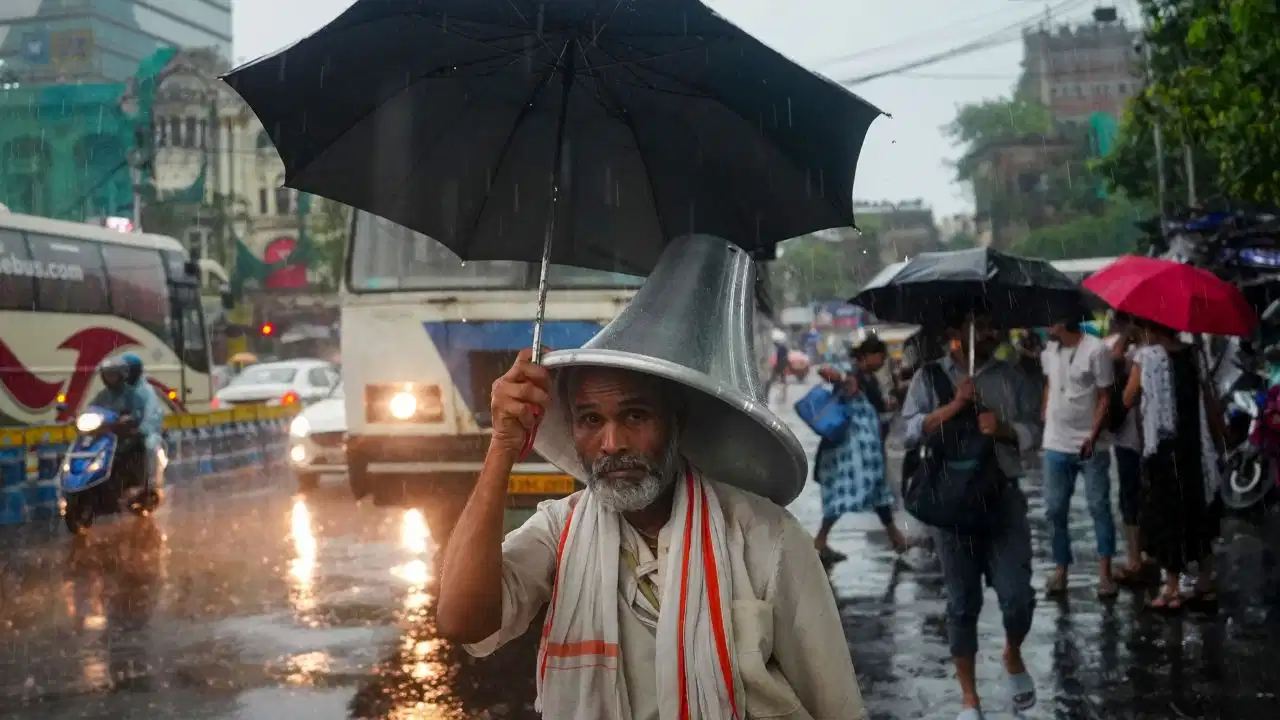 Dark monsoon clouds with rainfall over an Indian city as the latest Weather Update warns of heavy rain in 24 states and heatwave conditions in Uttar Pradesh.